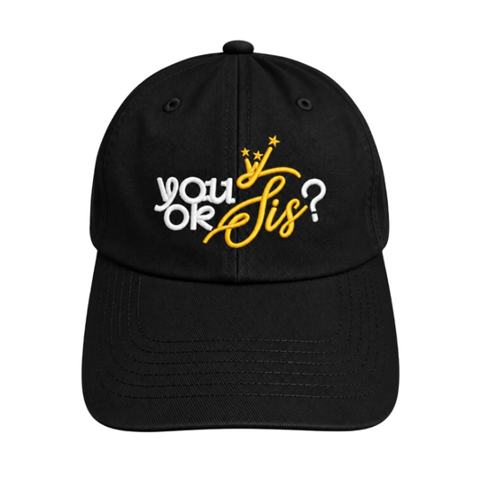 A black baseball cap with embroidered text reading 'you OK Sis?' in white and yellow, featuring a yellow crown and stars, on a light gray background.